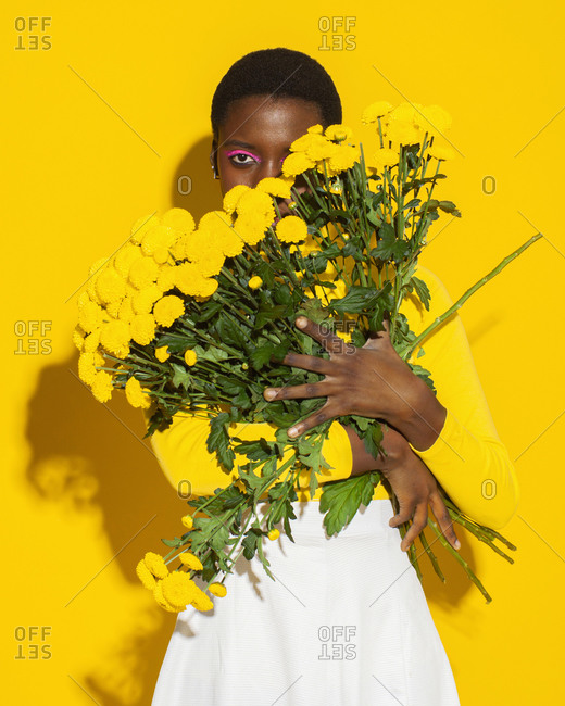 Sensual woman with yellow flowers, total yellow