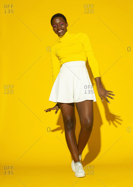 Young fashionable woman, total yellow style on yellow background