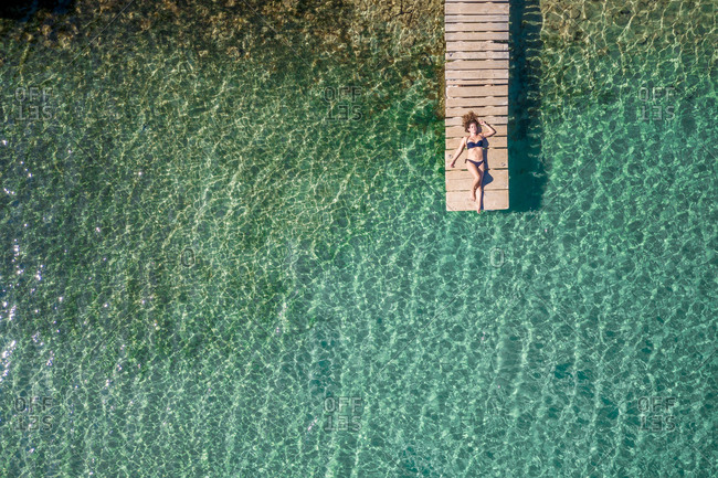 Vis, Croatia - 13 SEPTEMBER 2019: Aerial view of a woman on a pier at Stoncica beach