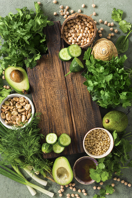 Top view vegetarian menu concept. Old wooden kitchen board with fresh green vegetables and grain top view