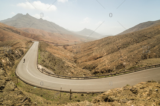 Fuerteventura, Spain. - March 1, 2018: Panoramic view of winding road with cyclists at Astronomical Viewpoint of Sicasumbre