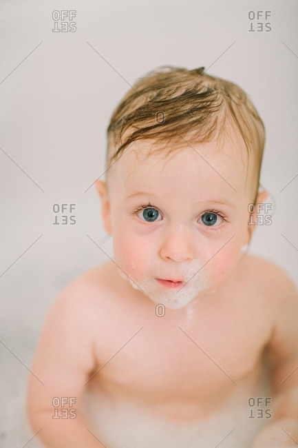 Closeup of baby in the bathtub with bubbles on face