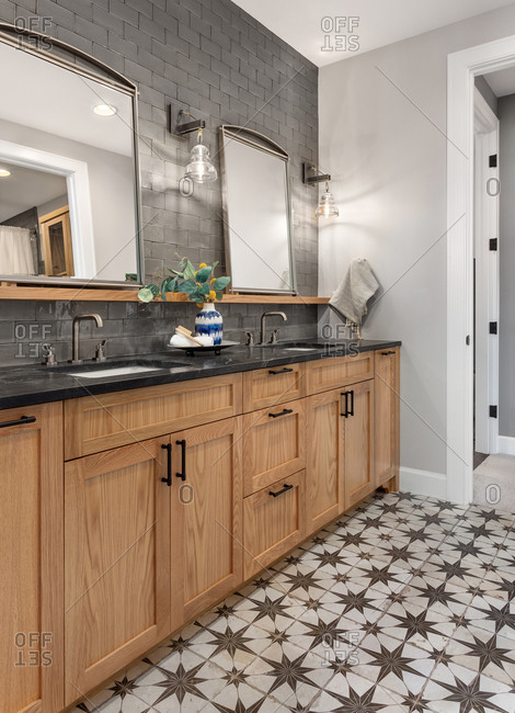Bathroom in luxury home with double vanity and ornate tile floor