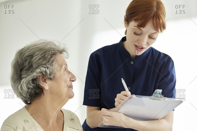 Nurse writing medical history of patient