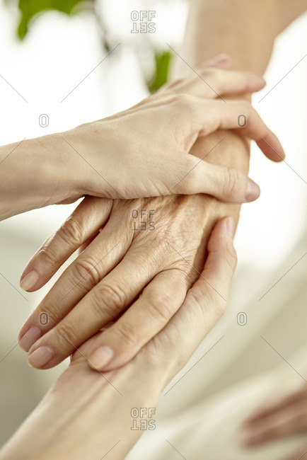 Nurse holding patient's hand softly