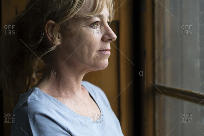 Close-up of thoughtful woman looking through window