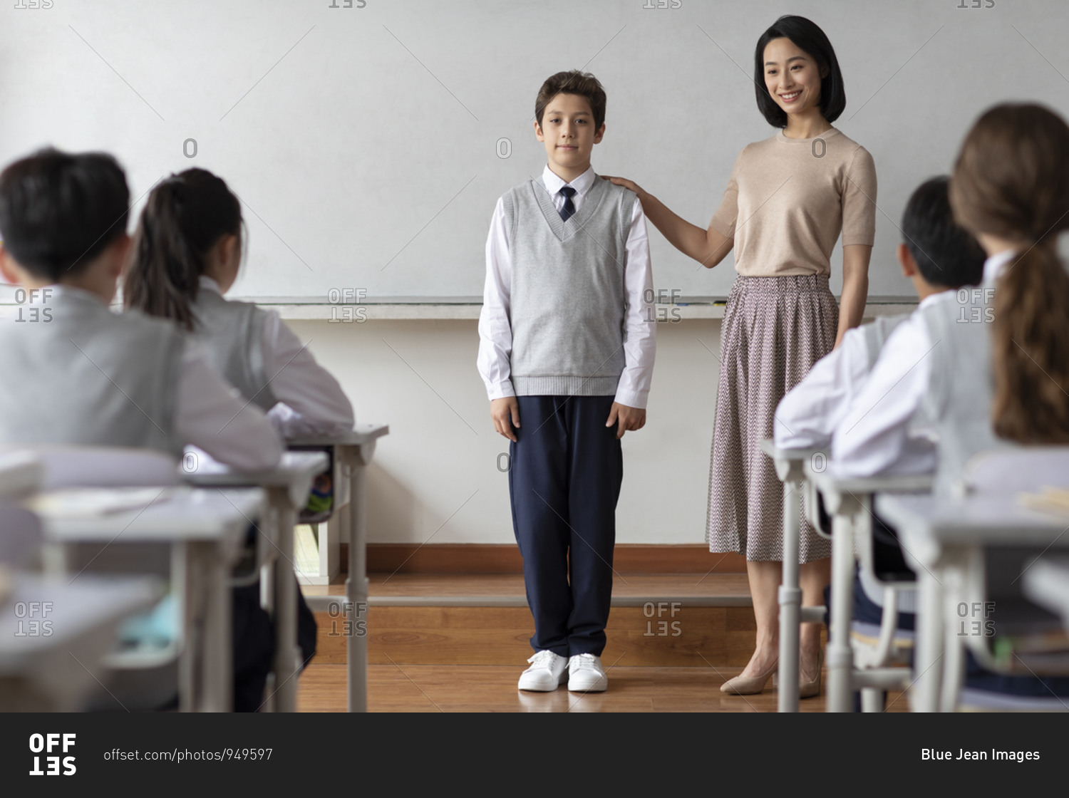 Young Chinese Teacher Introducing A New Classmate In Classroom Stock 