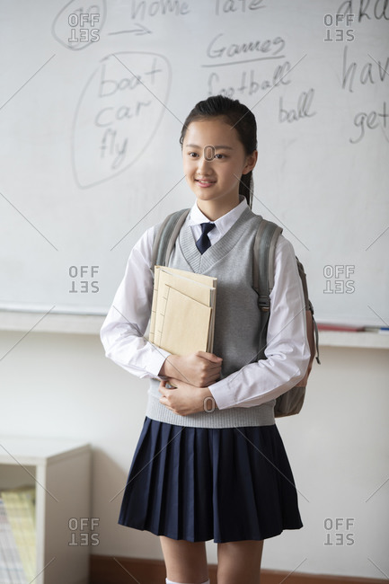 Chinese schoolgirl standing in classroom