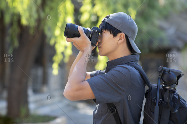Young Chinese photographer taking photos with camera
