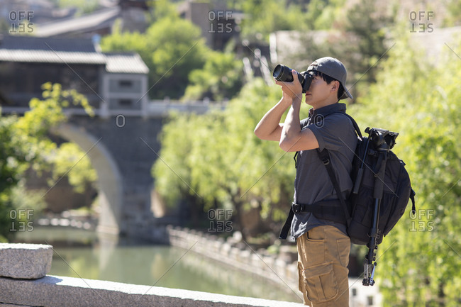 Young Chinese photographer taking photos with camera