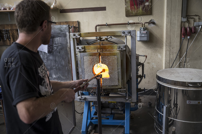 Berlin, Germany - June 10, 2017: Melting glass in a kiln during a glassblowing lesson at the Berlin Glass workshop in Wedding