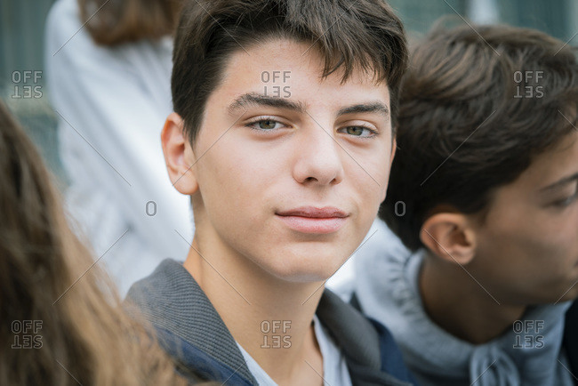 Close-up of teenage boy outside with his friends