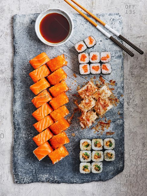 Minimalistic and clean maki sushi set on stone serving board on light background