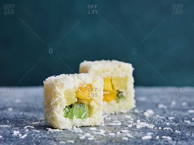 Close up of dessert sushi rolls with fresh tropical fruits and coconut