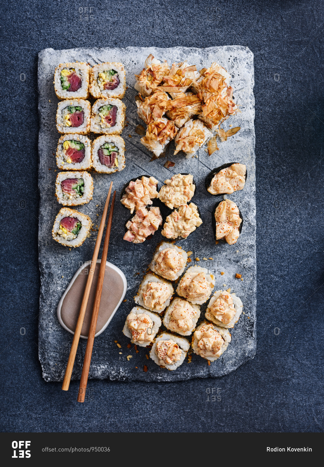 Selection of Japanese appetizing gunkan and maki rolls with fresh and flaked tuna on dark background