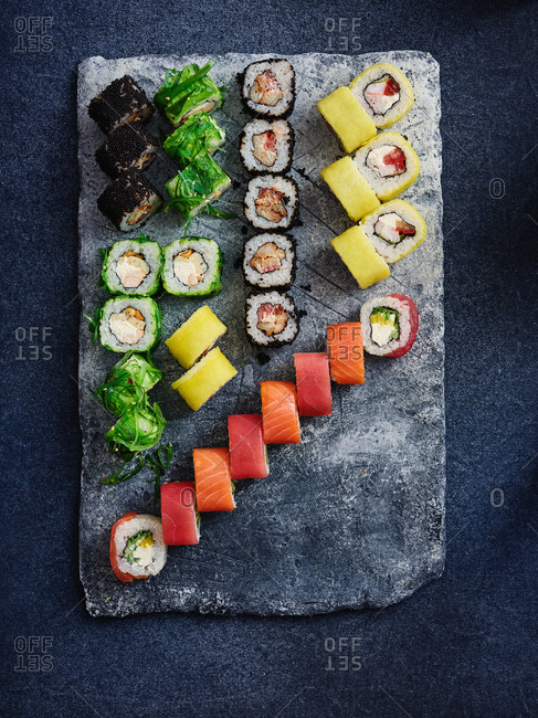 Assortment of sushi roll set on a black tray. Japanese food. Top