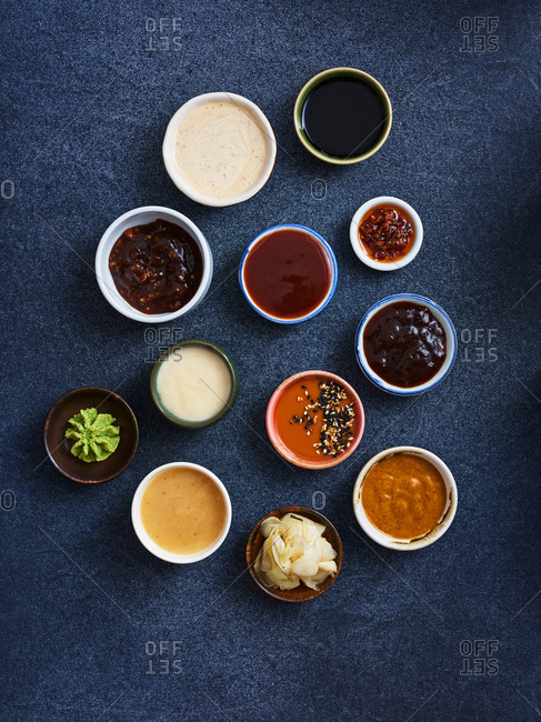 Various sauces and ingredients for oriental and asian cooking on dark textile background