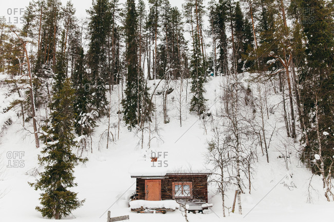 A rustic cottage on a snowy hill in rural Finland
