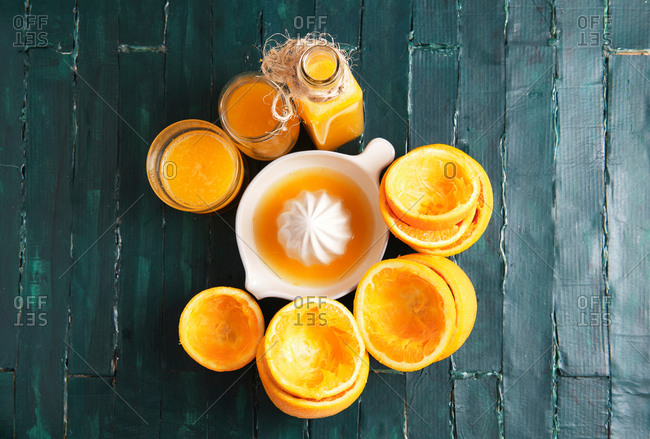 Still life of a green wooden base of an orange squeezer with orange juice