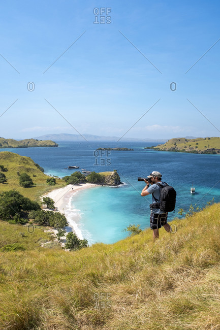 A photographer above Pink Beach in Komodo National Park, Indonesia.