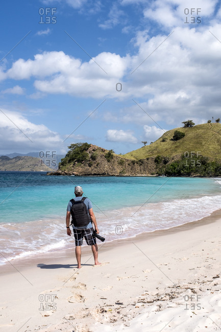 A photographer on Pink Beach in Komodo National Park, Indonesia.