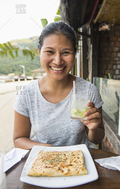 Woman enjoying a drink and a snack at the tropical Island Ilha Grande