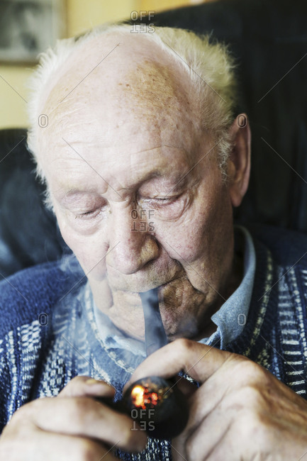 Germany- Senior man holding pipe- close up
