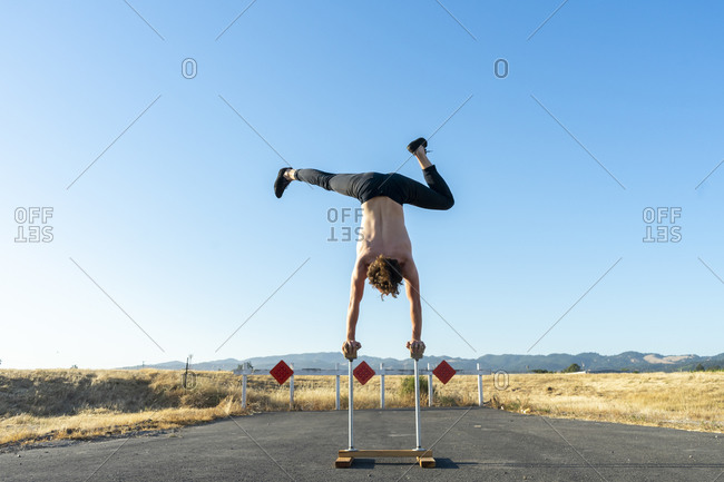 Acrobat doing handstand on handstand canes