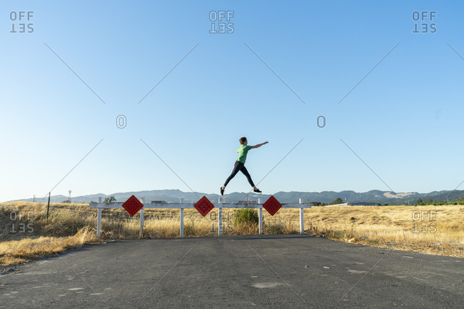 Acrobat balancing on barrier outside