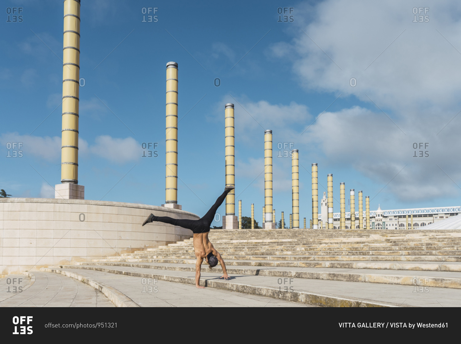 Young man doing acrobatics on stairs outdoors