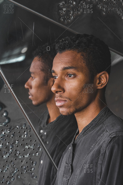 Portrait of young man at mirrored wall