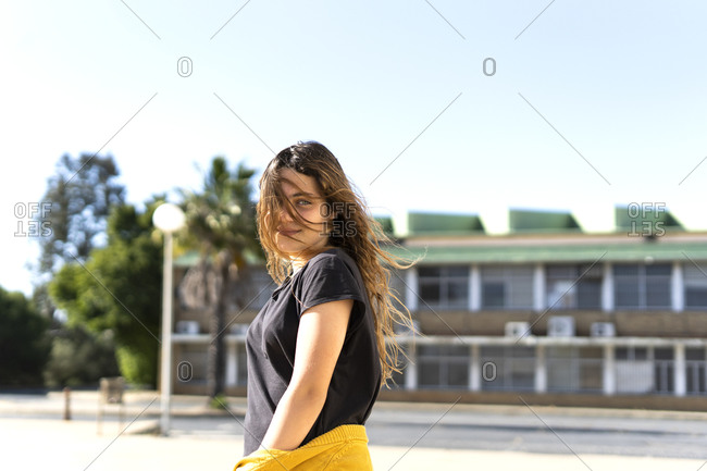 Portrait of smiling teenage girl with windswept hair