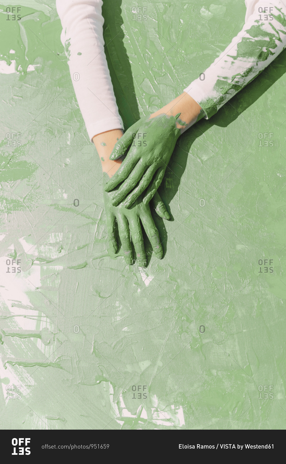 Green hands of young woman on green painting