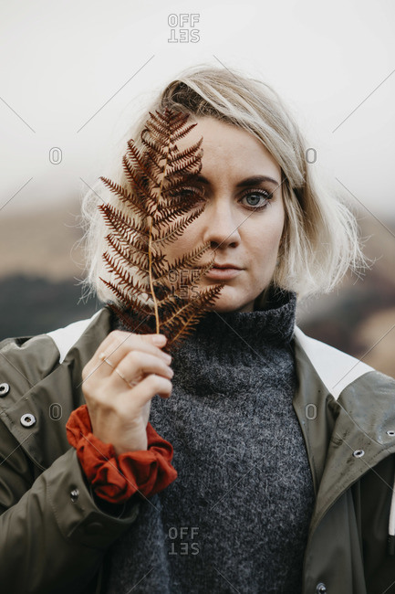 UK- Scotland- Highland- portrait of young woman holding fern
