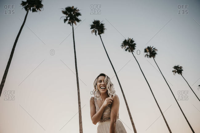 Low angle view of happy bride under palm trees