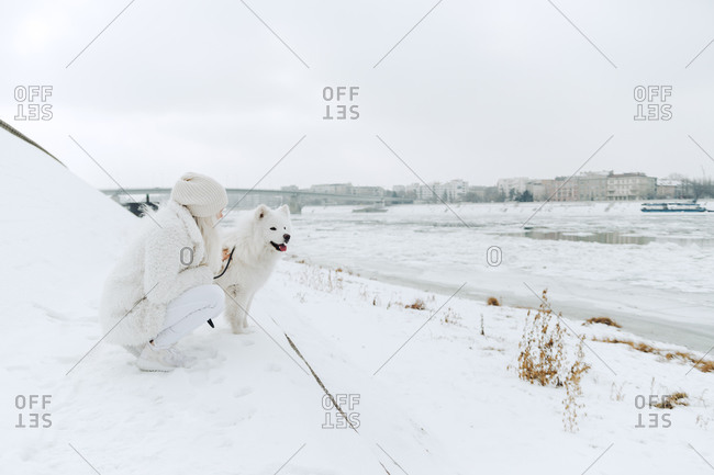 Serbia- Petrovaradin- white dressed young woman with white dog at riverside