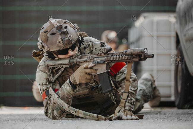 Soldier aiming airsoft gun during tactical game