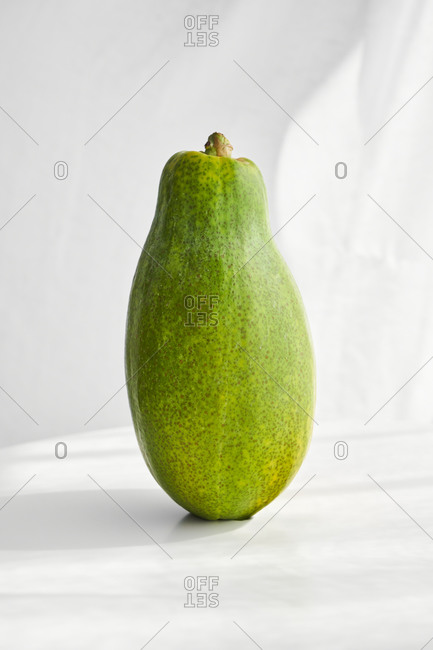 Whole fresh healthy papaya with seeds placed on white background