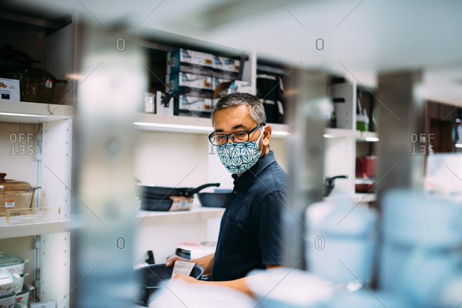 Asian man shopping in a store while wearing a facemask