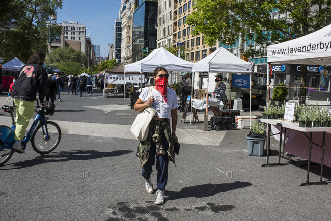 New York City, New York, USA - May 21, 2020: Market -goer wearing bandana as a face covering while shopping at the Union Square Farmer's Market, New York City, USA.