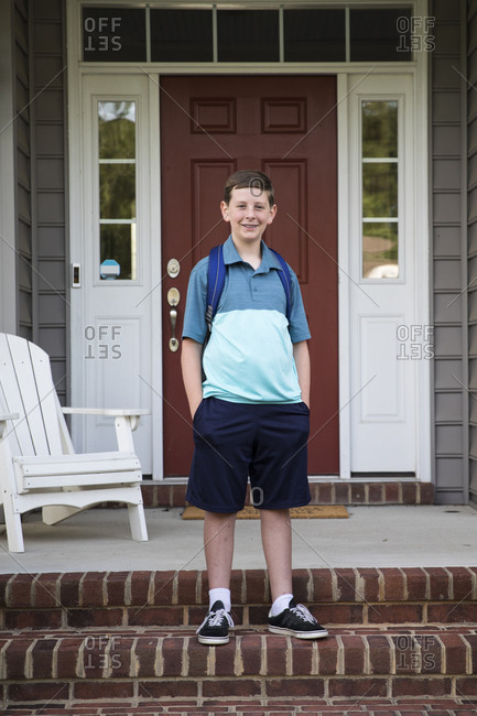 Smiling Tween With Braces Stands on Brick Front Porch Steps