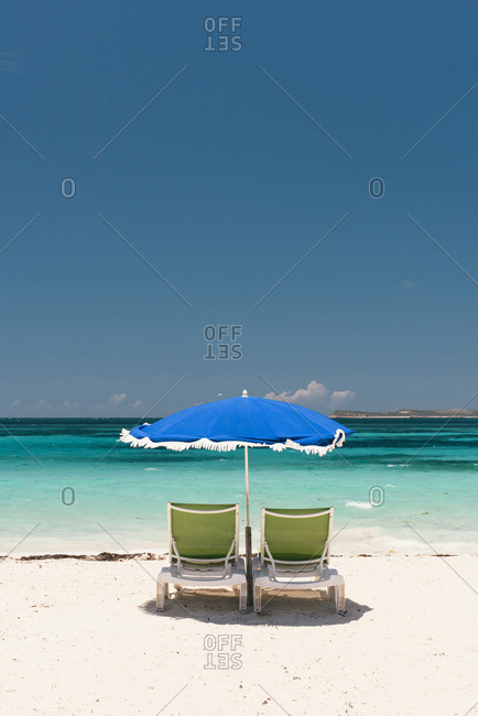Two beach chairs and umbrella ready for tourists on the beach