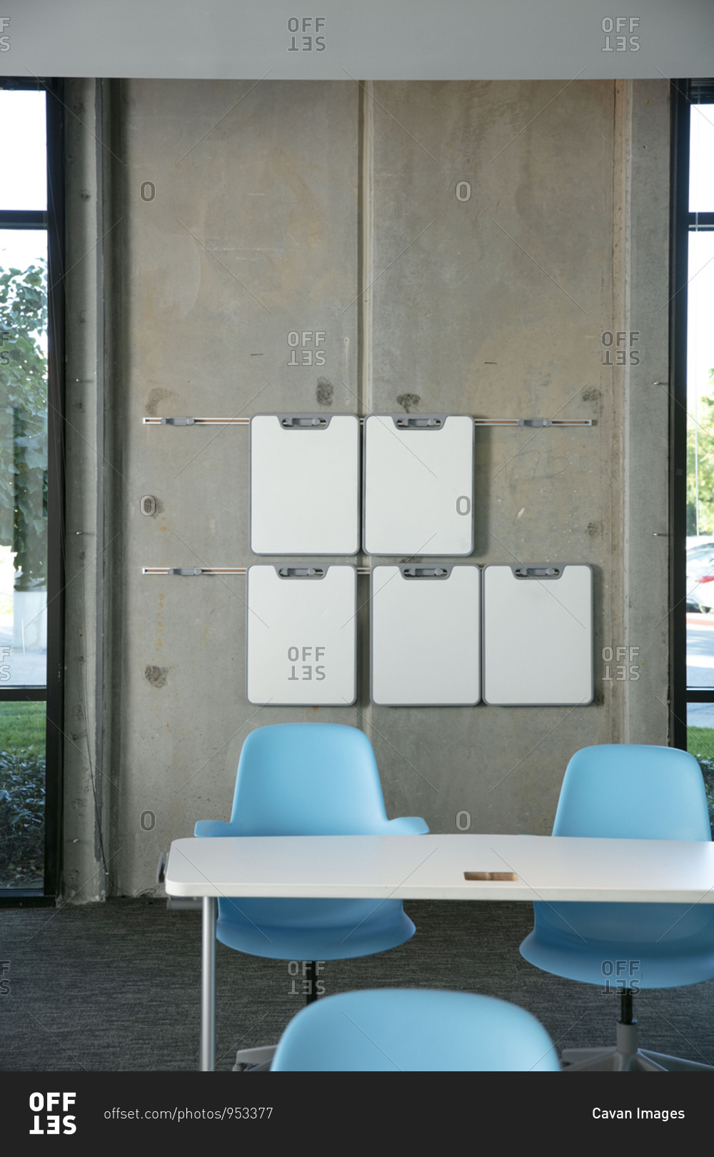 A classroom with white dry erase boards hanging from the wall