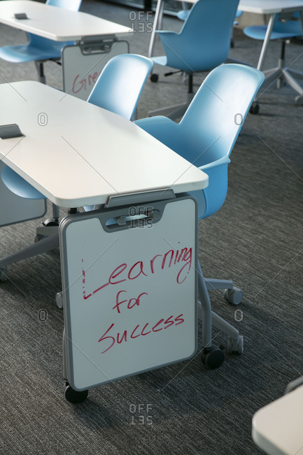 Close up shot of a table with blue chair with dry erase boards