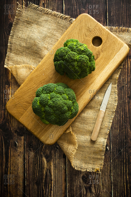 Place mat- cutting board- kitchen knife and fresh broccoli