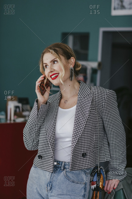 Portrait of smiling beautiful woman with red lipstick talking on the phone