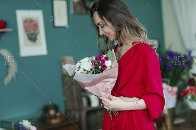 Smiling woman with a bouquet of flowers in a flower shop