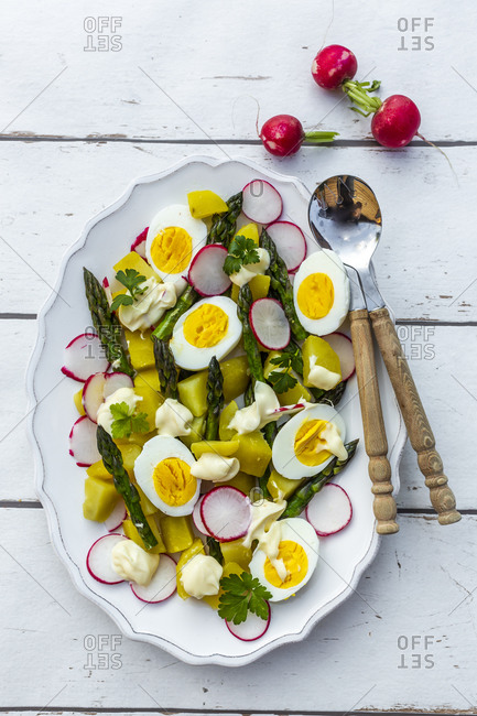 Plate of vegetarian potato salad with boiled eggs- asparagus- radishes and parsley