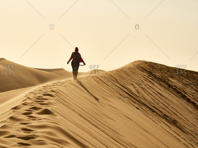 Woman on the ridge of a dune in the desert- Walvis Bay- Namibia