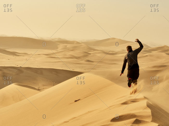 Man running on a dune in the desert- Dune 7- Walvis Bay- Namibia